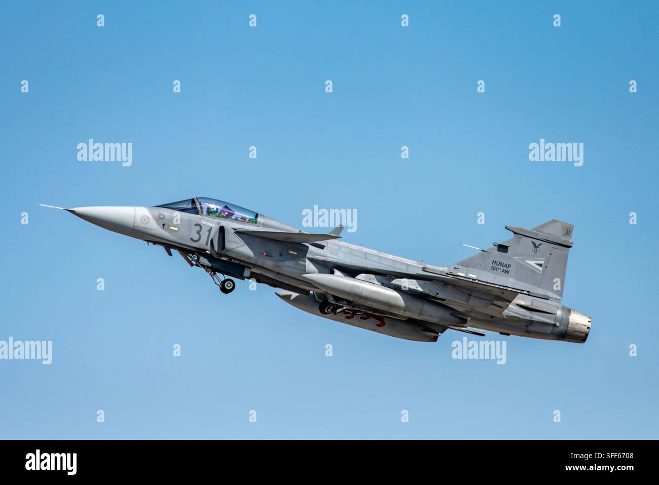 Aereo da combattimento Saab JAS 39D Gripen dell'Aeronautica Militare Ungherese in decollo sotto un cielo blu terso, foto di aviazione militare Foto Stock