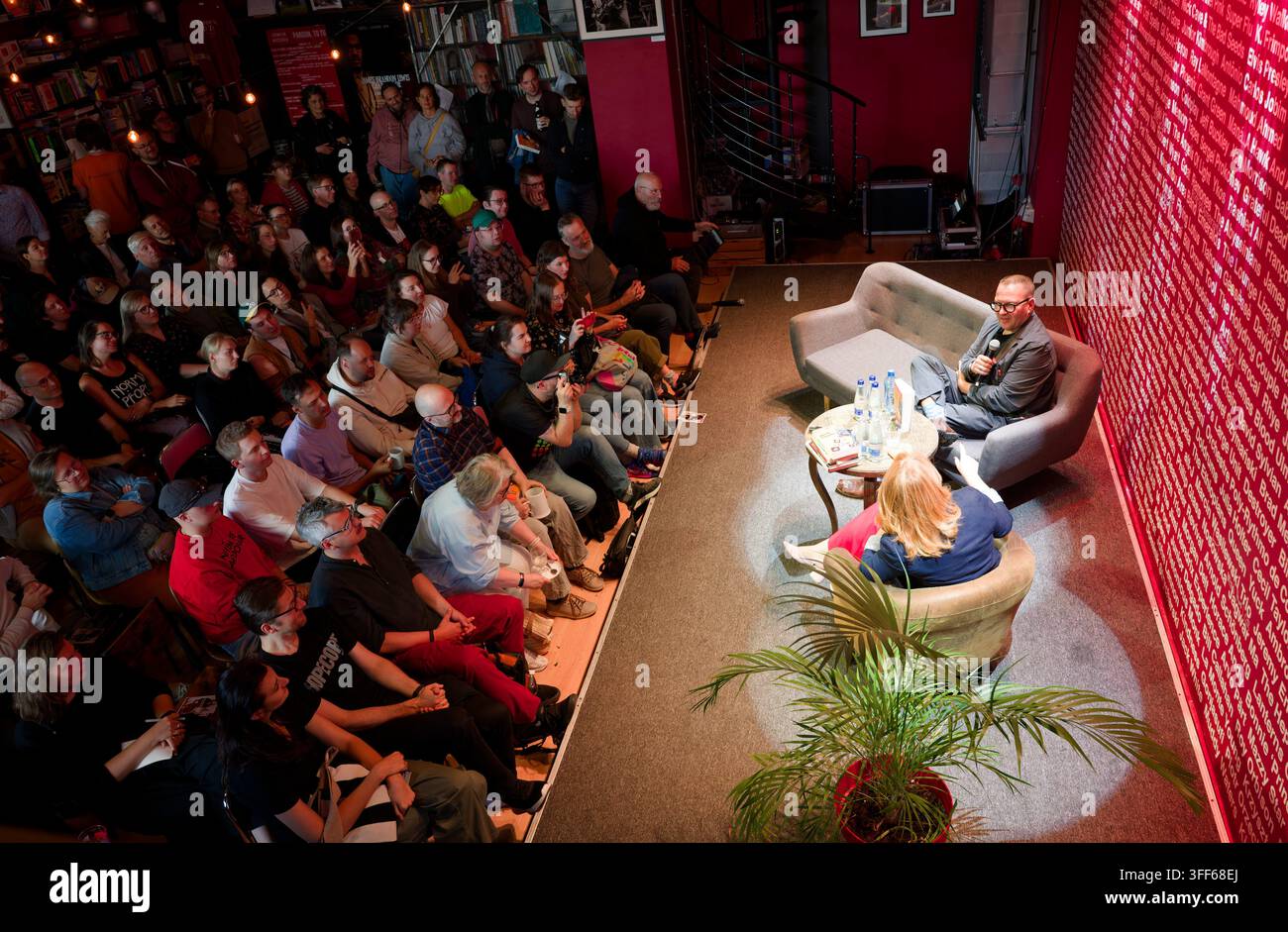 Cory Doctorow e Sylwia Czubkowska sul palco durante un evento affollato che segna il lancio dell'edizione polacca del libro "Enshittification". Foto Stock