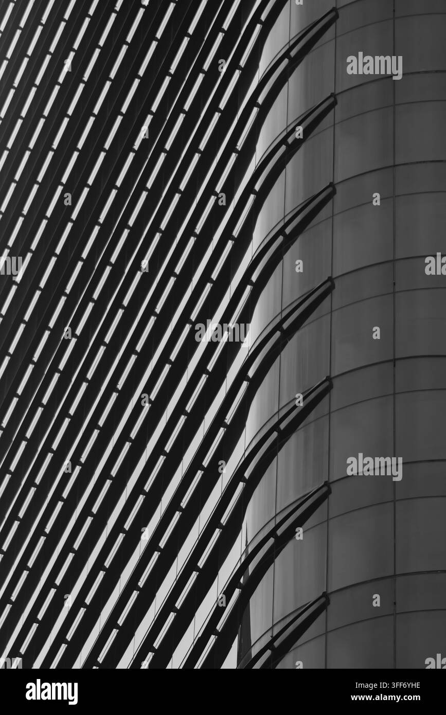 Scatto architettonico di una facciata di grattacielo moderno con pannelli di vetro eleganti e griglie di acciaio strutturate Foto Stock