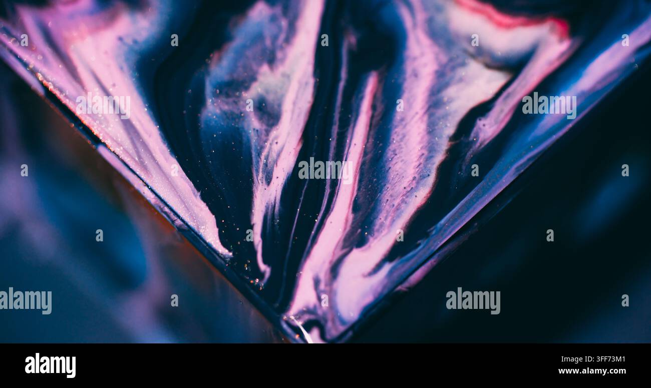 Fluido scintillante. Versamento di inchiostro. Texture acrilica in miscela triangolare di glitter blu, viola e rosa sfocati che galleggiano su uno sfondo artistico astratto. Foto Stock