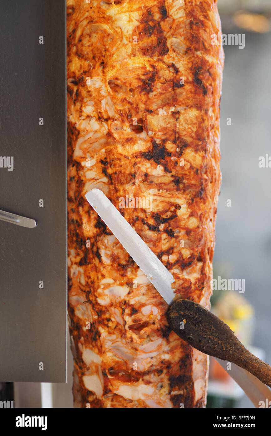 Shawarma Doner Kebab su spit verticale tagliato per involtini e panini da street food Foto Stock