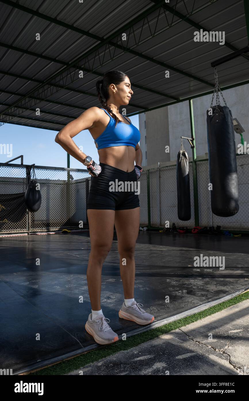 Atleta femminile determinata si riposa durante l'allenamento di boxe Foto Stock