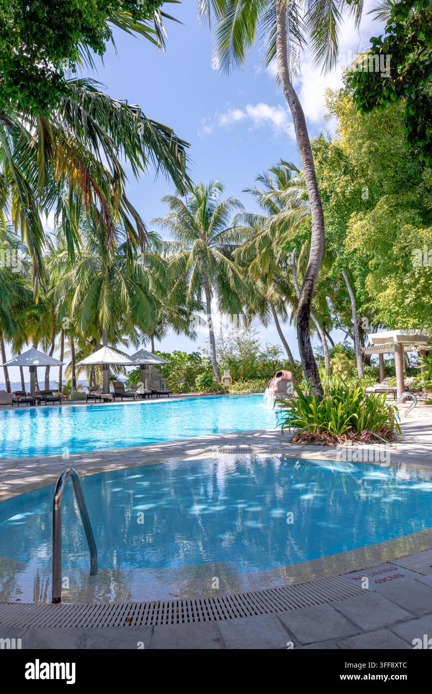 Ampia piscina aperta del resort che si affaccia sul vasto oceano blu Foto Stock