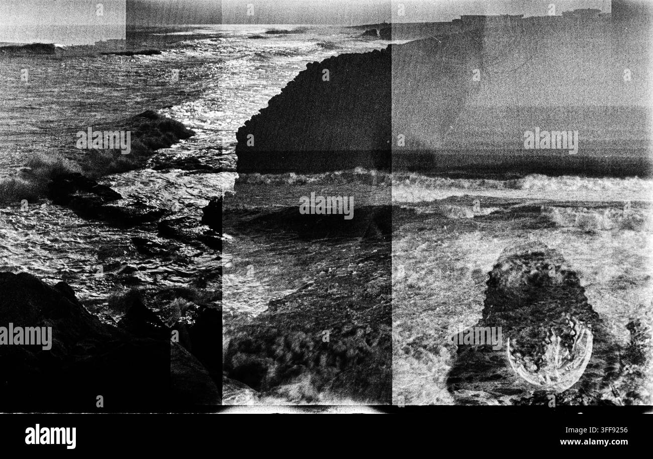 Le esposizioni sovrapposte dividono una costa rocciosa dell'oceano in pannelli verticali, creando una composizione sperimentale granulosa in bianco e nero su pellicola. Foto Stock