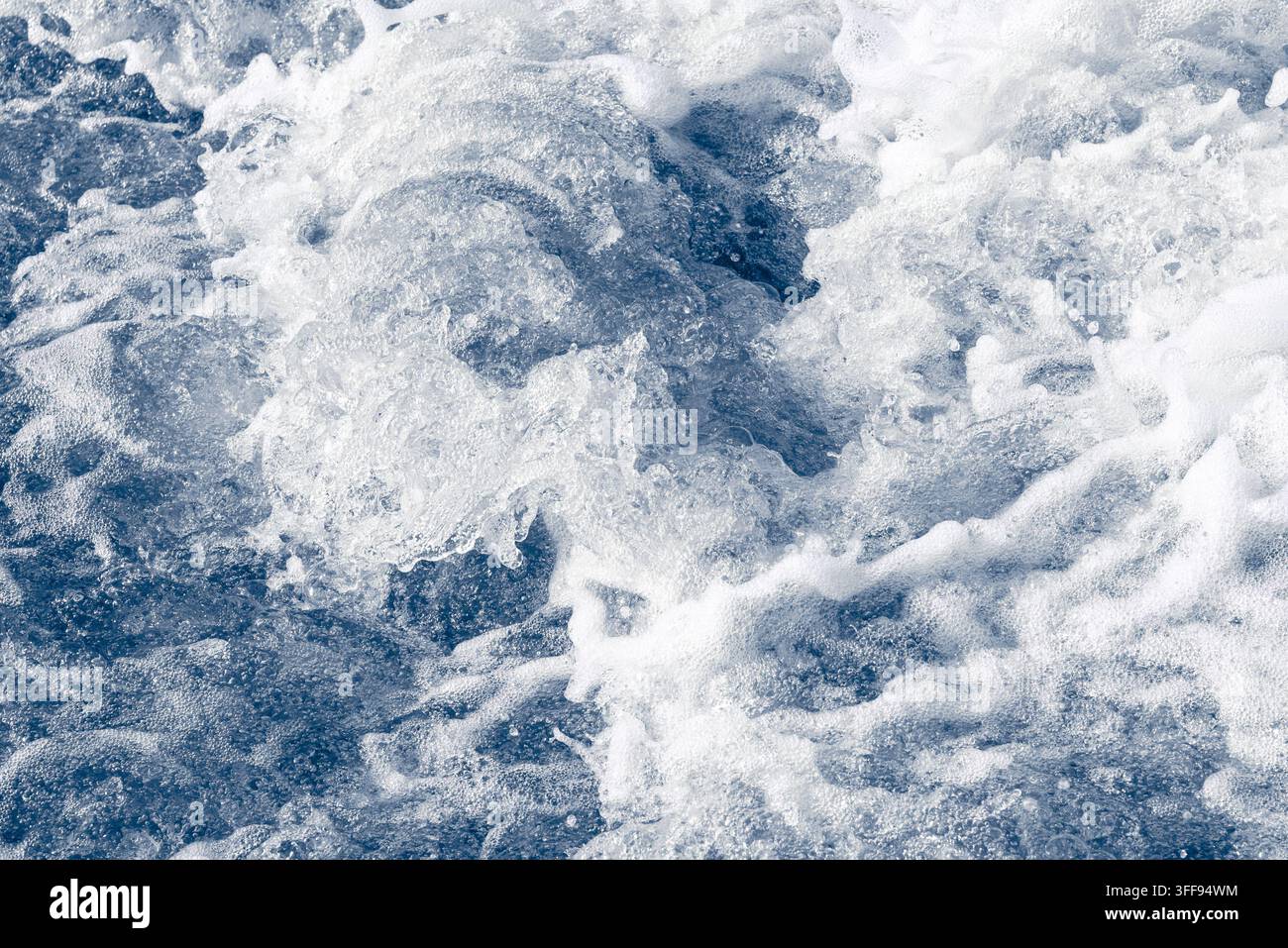 Corrente fredda e vorticosa del fiume con acqua azzurra agitata e schiuma bianca. Foto Stock