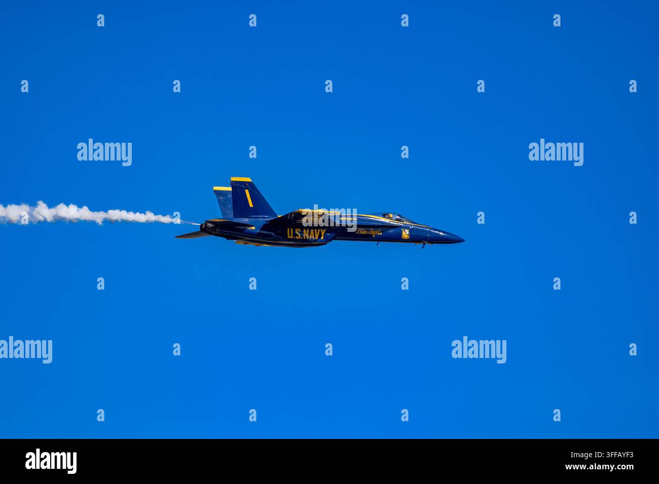 Meridian, MS - 28 marzo 2026: U.S. Navy Blue Angels F/A-18 Super Hornet in volo durante una dimostrazione aerea con una scia di fumo bianca contro un cielo sereno Foto Stock