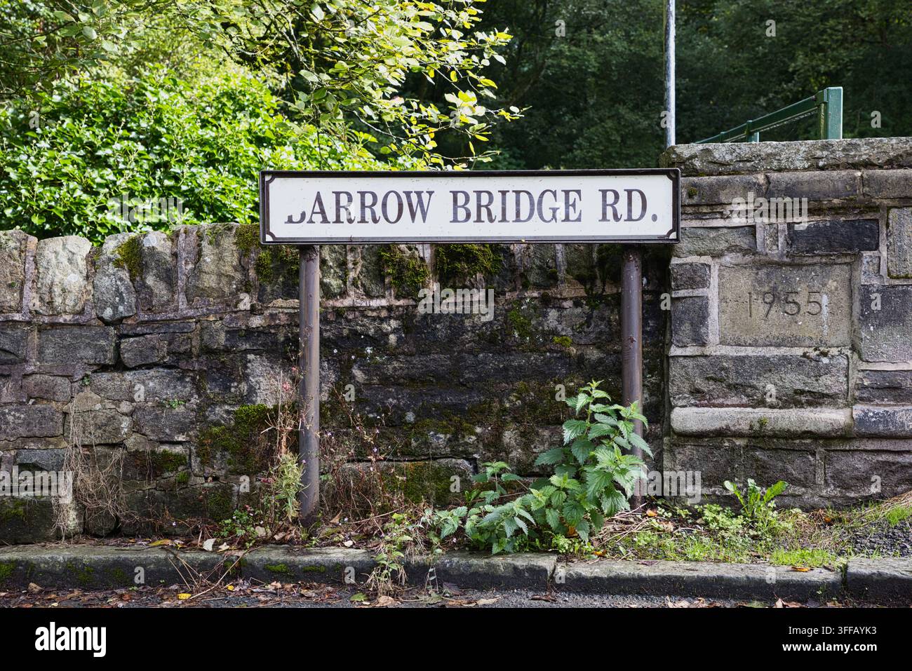 Insegna tradizionale del nome della strada per Barrow Bridge Rd montata su un vecchio muro di pietra con una pietra datata del 1955 a Bolton, Greater Manchester, Lancashire, Regno Unito. Foto Stock