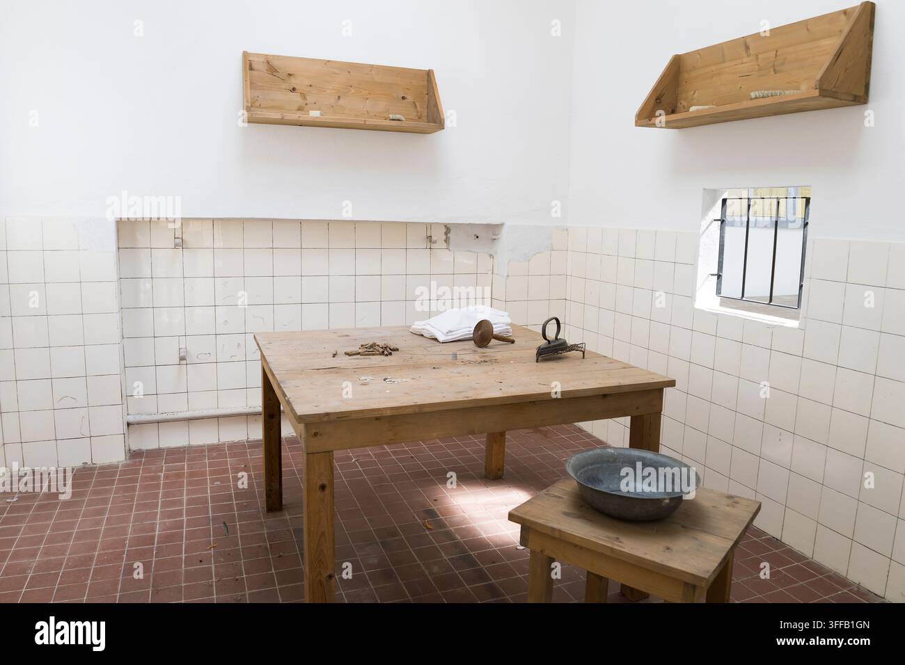 Una stanza con un tavolo di legno e mobili semplici. Questo luogo ha servito uno scopo storico. Foto Stock