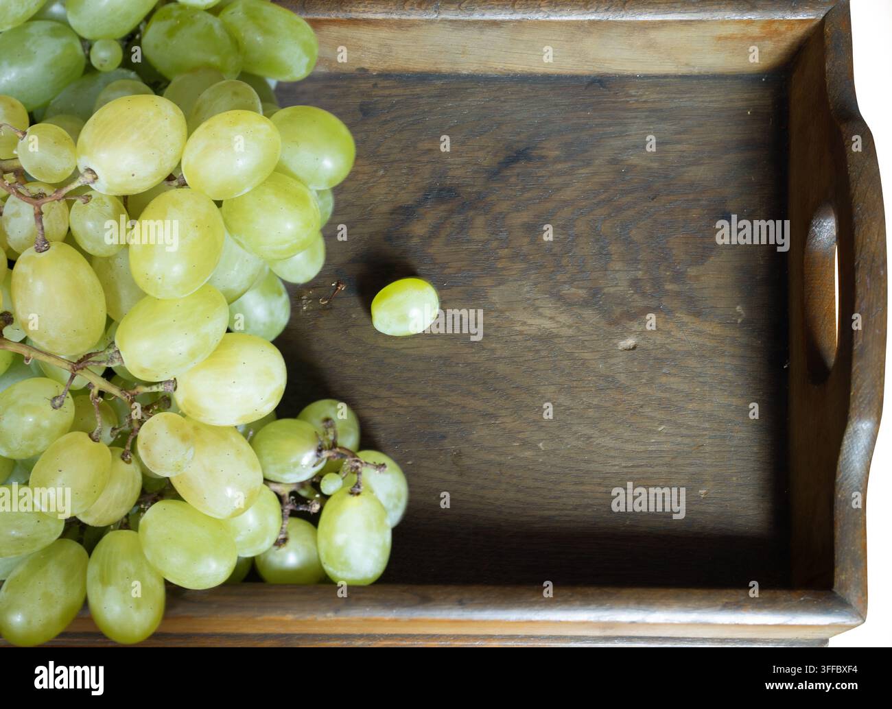 Uva verde fresca su vassoio di legno rustico con spazio per il testo Foto Stock