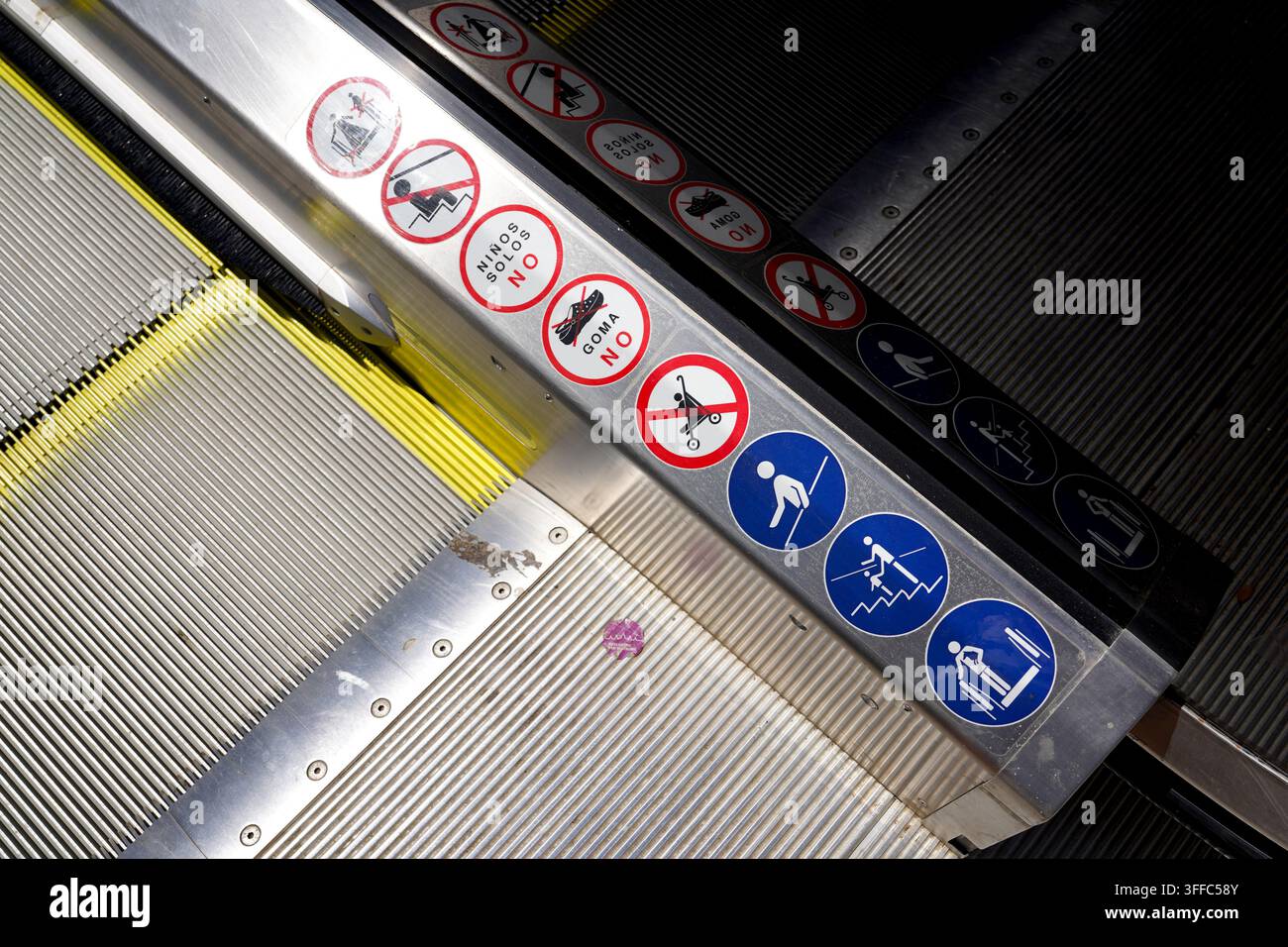 Prima vista del bordo della scala mobile in metallo che mostra segnali di sicurezza e avvertimento nel sistema di trasporto pubblico di Barcellona Foto Stock