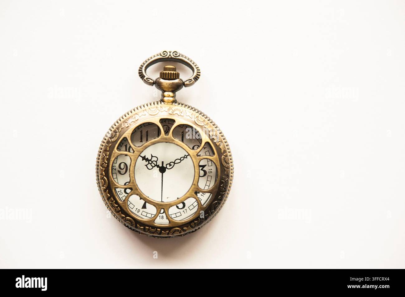 Orologio da tasca in ottone in stile antico isolato su bianco, con cassa ornata e quadrante decorativo con lancette e numeri neri Foto Stock