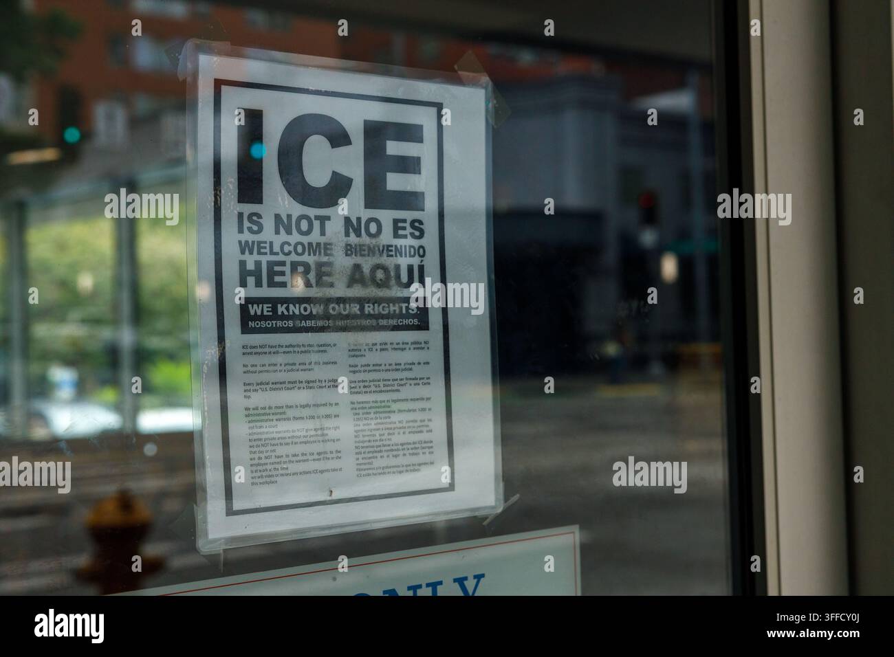Seattle, USA - 29 agosto 2026: Un poster bilingue "ICE Is Not Welcome Here, We Know Our Rights" attaccato all'interno di una vetrina del centro città, che elenca lega Foto Stock