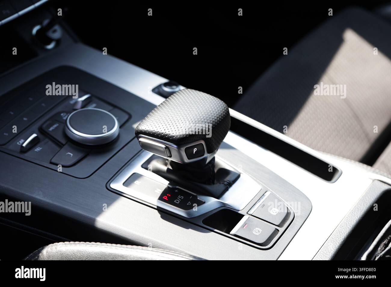 Dettaglio ravvicinato della console centrale di un veicolo di lusso, con elementi di design contemporaneo. La leva del cambio mostra P per parcheggio, circondata da finiture metalliche Foto Stock