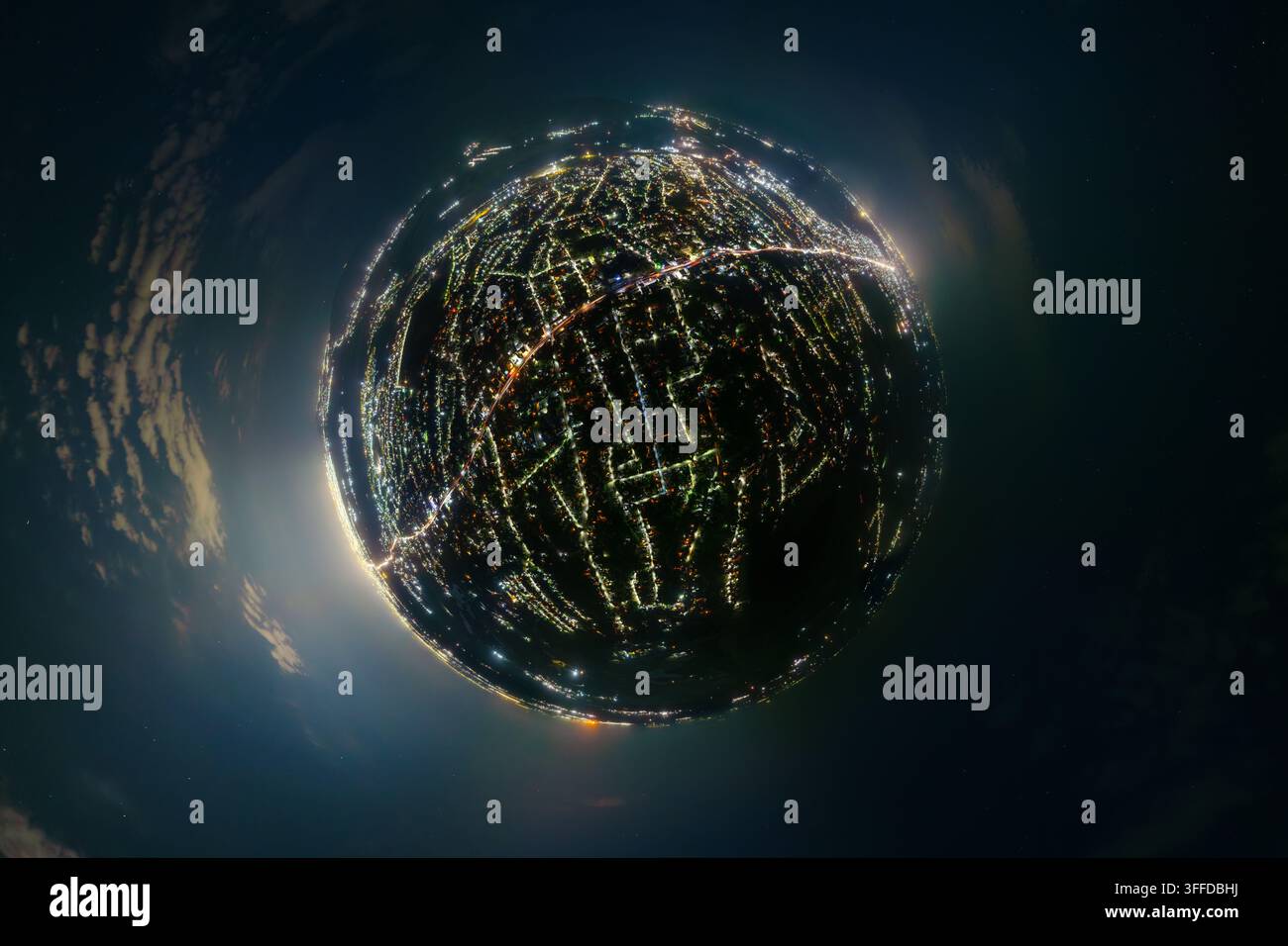 Vista panoramica di una città di notte in una prospettiva di piccolo pianeta. Le luci brillanti della città formano una sfera luminosa contro un cielo scuro pieno di stelle e nuvole. Periferie del Kirghizistan. Foto Stock