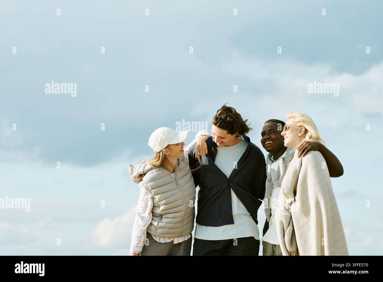 Gruppo diversificato di amici che camminano e ridono all'aperto Foto Stock