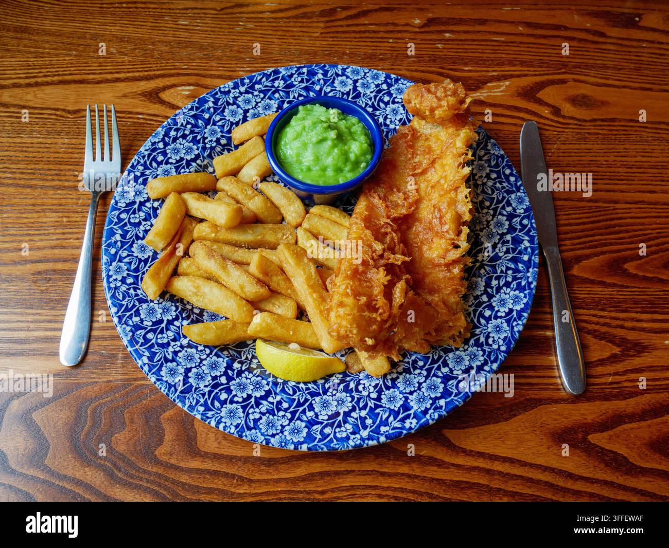 Piatto di pesce britannico impanato e patatine fritte servito in un pub JD Wetherspoon, Inghilterra, Regno Unito Foto Stock