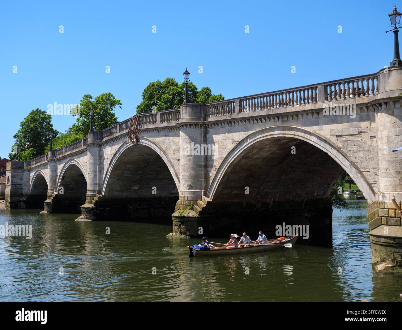 Persone che remano la loro barca a noleggio sotto un arco di pietra del Richmond Bridge sul Tamigi, Londra, Regno Unito Foto Stock