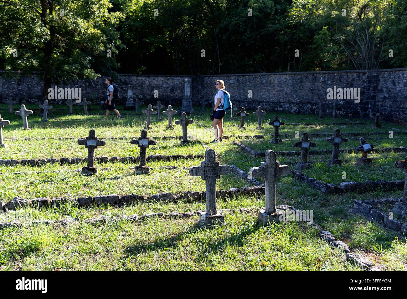 Cimitero militare austro-ungherese storico con lapidi di pietra erose di soldati della Prima Guerra Mondiale tra gli alberi autunnali a Brje pri Komnu. Foto Stock