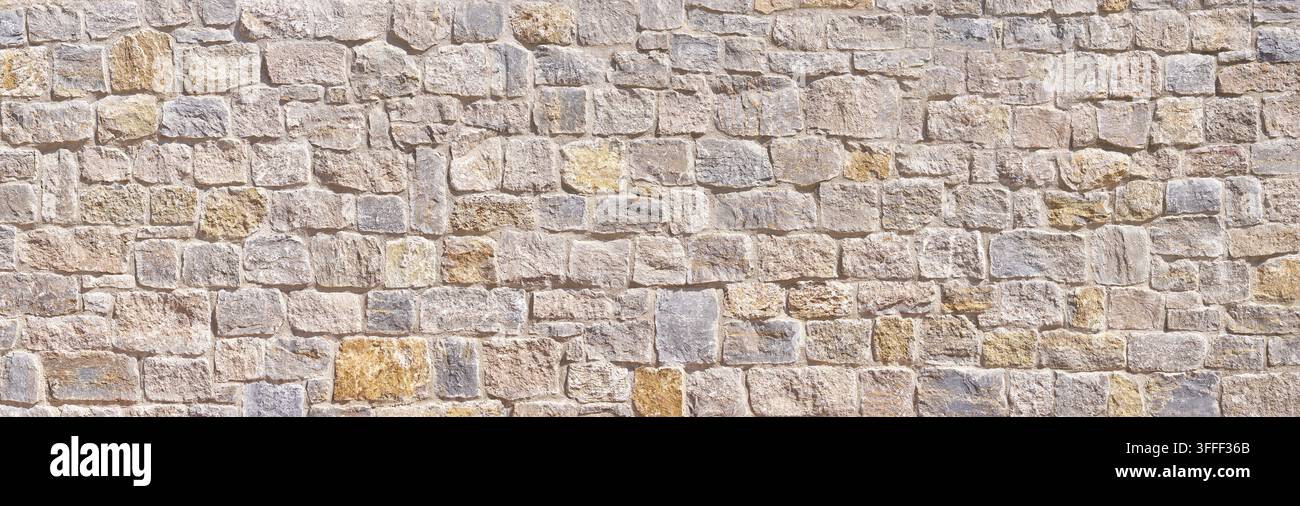 Muro antico in pietra naturale chiaro alla luce del sole Foto Stock