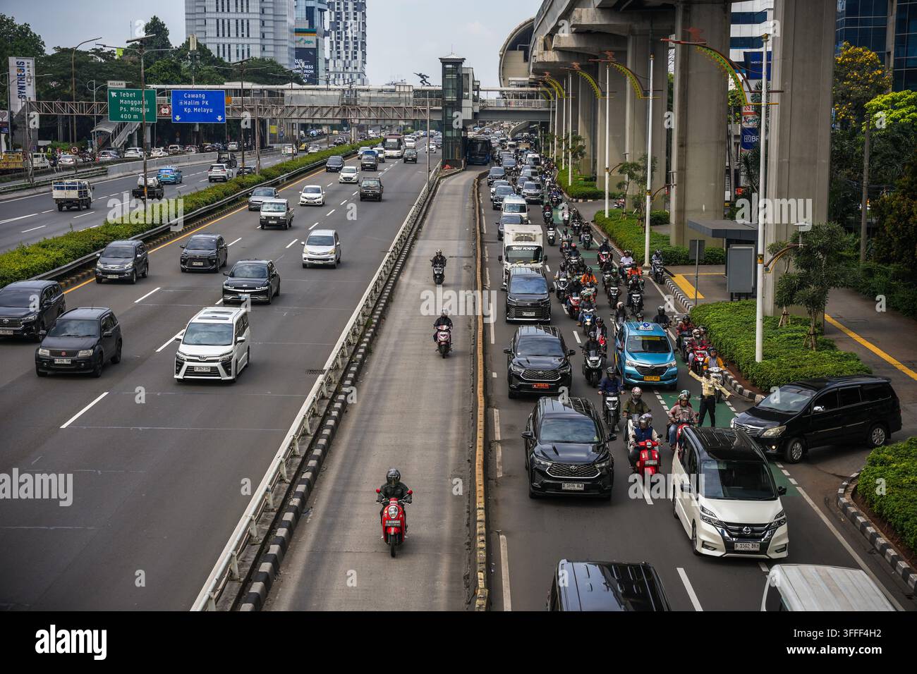 Vista di traffico intenso con auto e motociclette su un'autostrada urbana affollata a Jakarta, Jakarta, Indonesia. Foto Stock