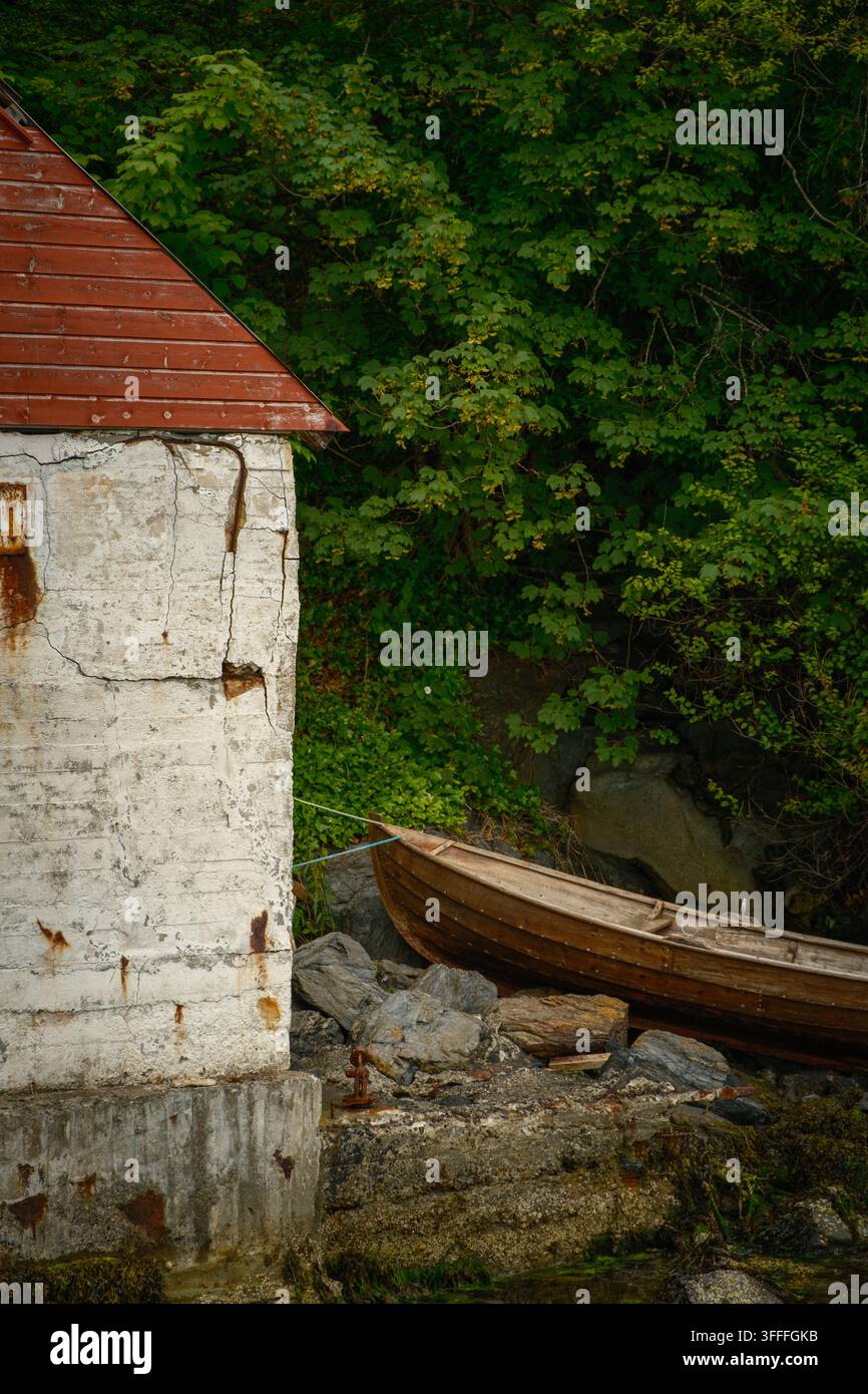 Vecchio capannone consumato e barca a remi in legno a Leirvik, Norvegia Foto Stock