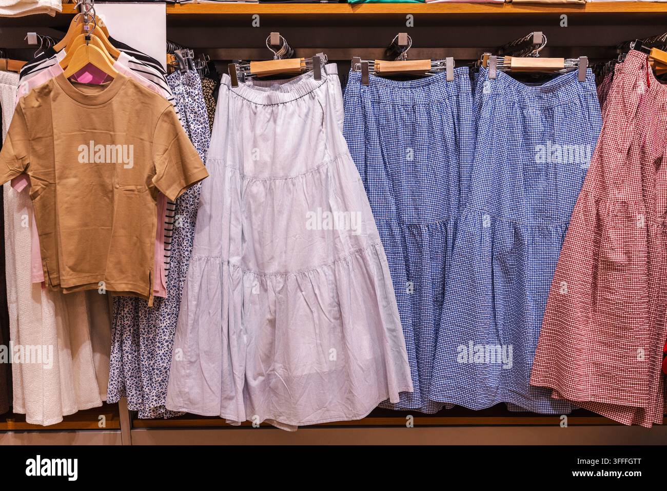 Abiti e gonne colorati su una rastrelliera per vestiti Foto Stock