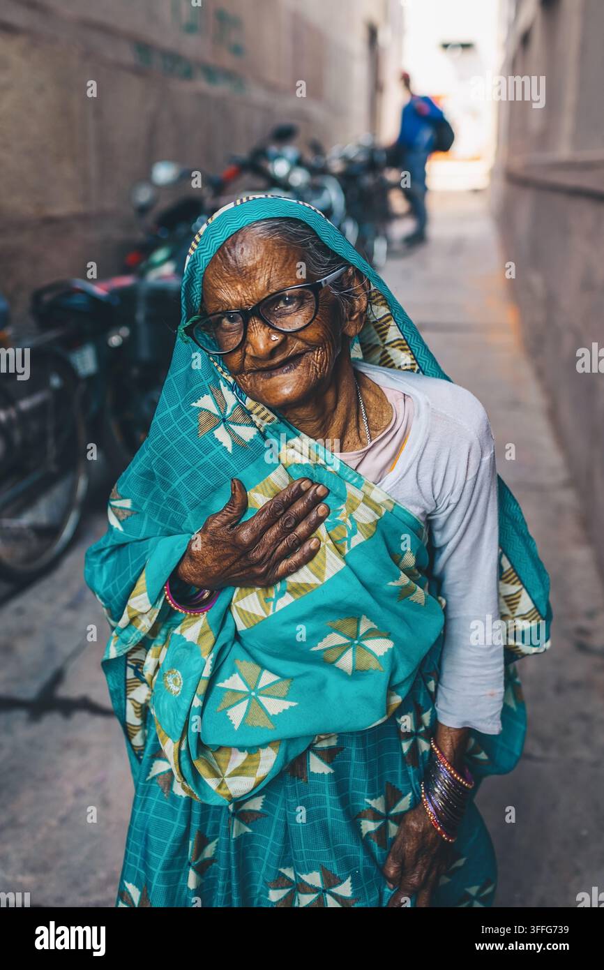 Anziana donna in abiti tradizionali che guarda l'obiettivo a Nuova Delhi, India. Foto Stock