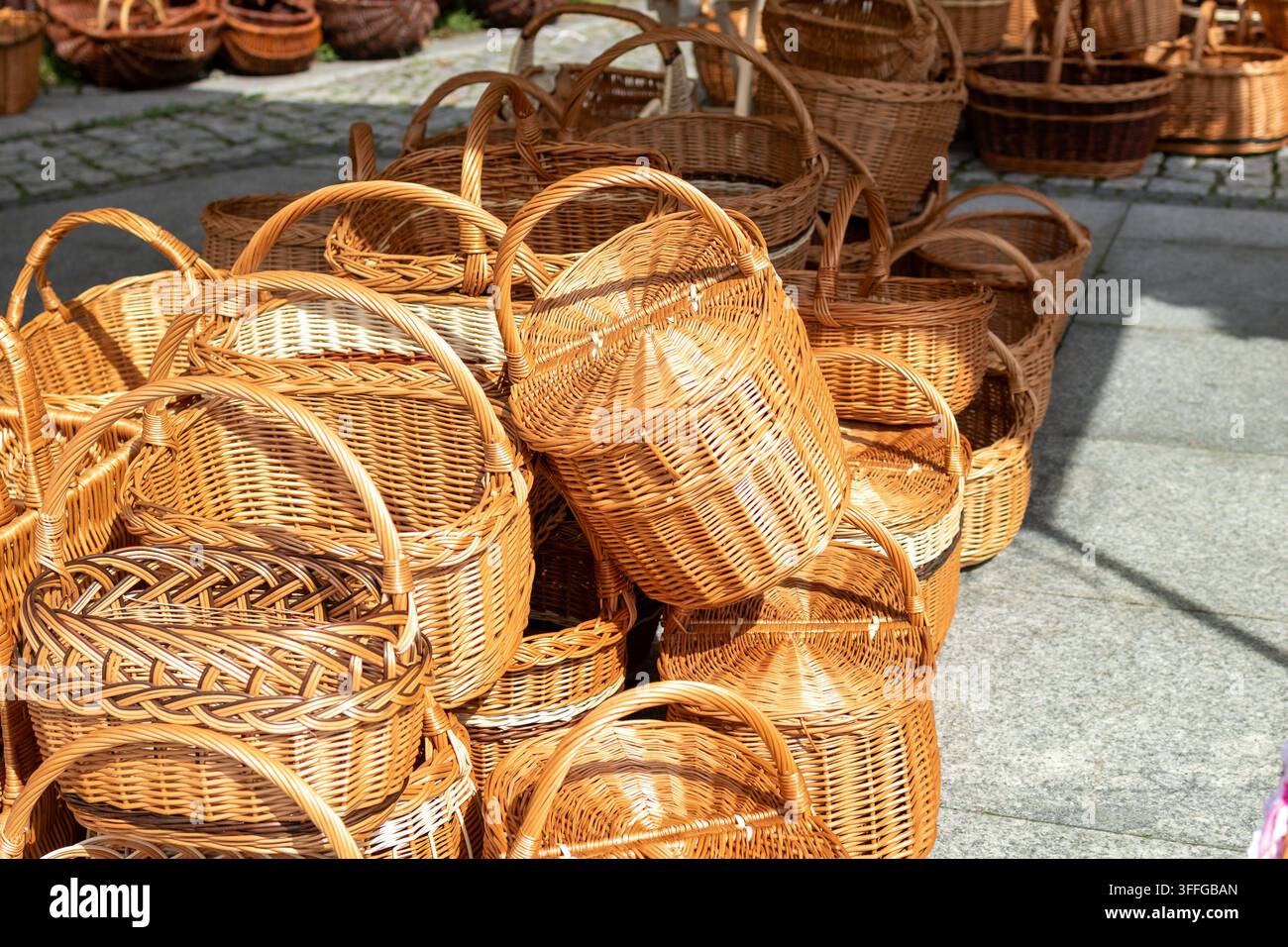 Cestini in vimini naturale sono esposti in un mercato artigianale all'aperto, inclusi cestini con manici e contenitori per uso domestico. Artigiano tradizionale Foto Stock