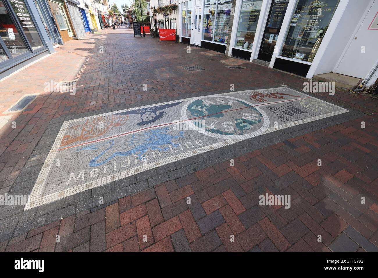 La linea del meridiano di Greenwich su Sun Street a Waltham Abbey, il mosaico raffigura una coppia di draghi, re Enrico VIII e la chiesa dell'abbazia, nell'Essex, Regno Unito. Foto Stock