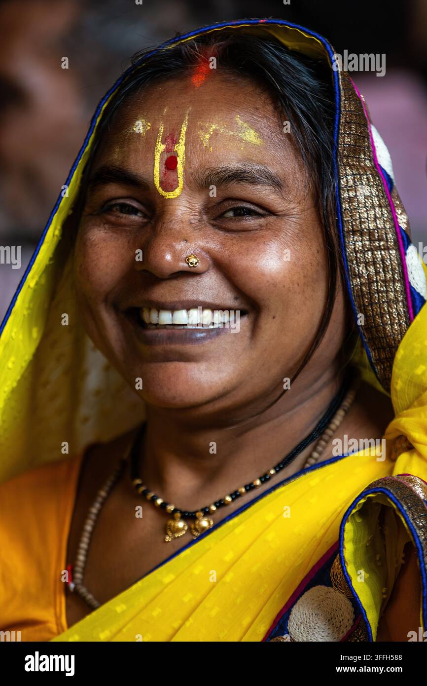 Donna indiana sorridente in un sari giallo con segno tradizionale sulla fronte a Nuova Delhi Foto Stock