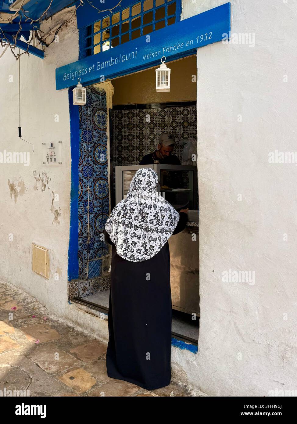 Donna del posto in una bottega tradizionale di bambalouni e beignet fondata nel 1932 a Sidi Bou Said, Tunisia. Foto Stock