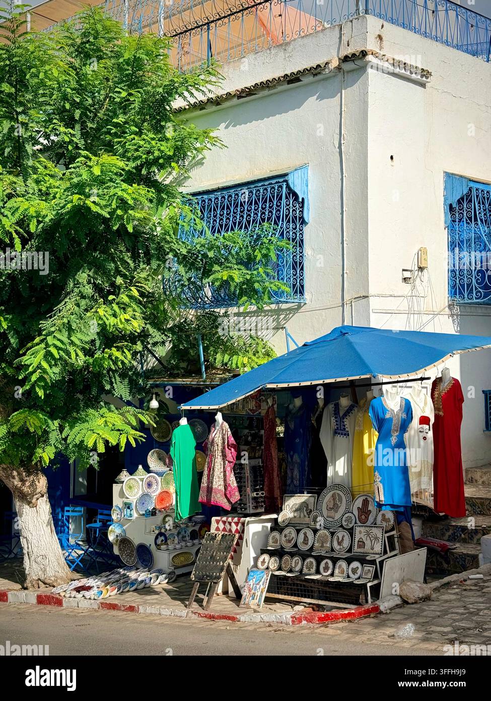 Negozio tradizionale di artigianato e souvenir con ceramiche e abbigliamento a Sidi Bou Said, Tunisia Foto Stock
