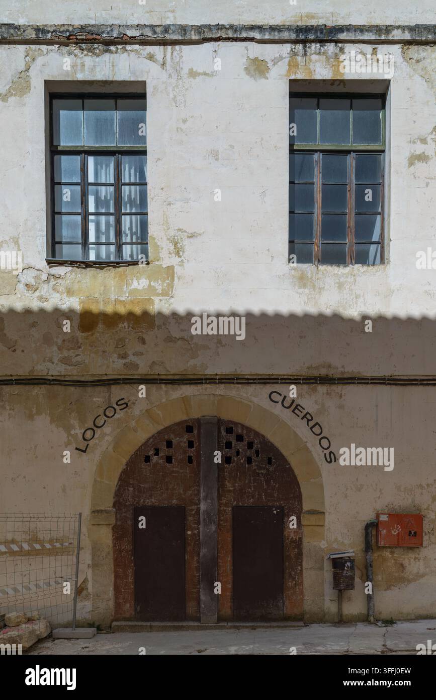Antica facciata a Oña, Burgos, con le scritte "Locos" e "Cuerdos" sopra una porta ad arco nel Giardino Segreto del Monastero di San Salvador. Foto Stock