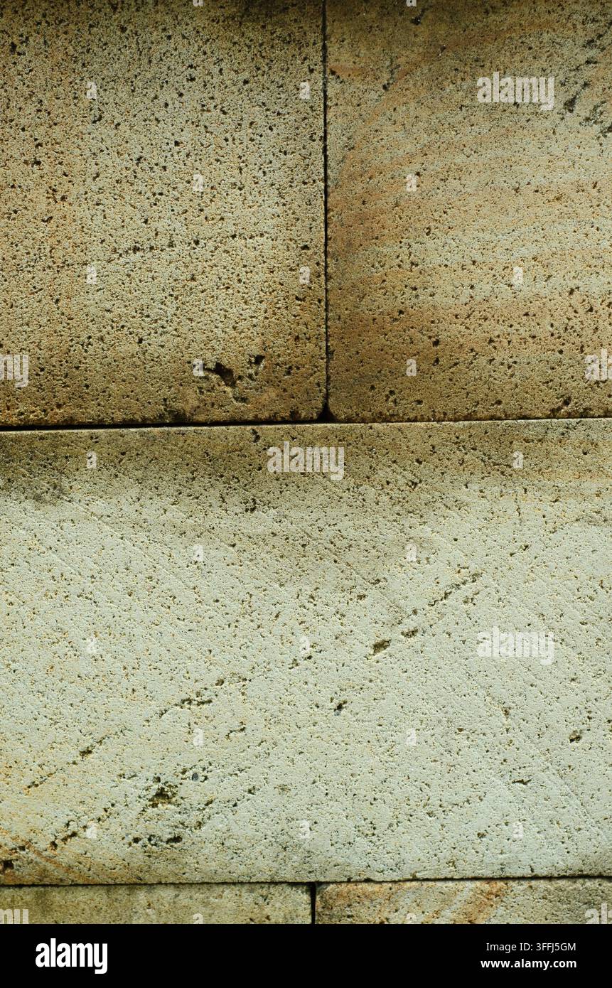 Prima vista di blocchi di muro in pietra naturale con texture ruvida e porosa e tonalità beige-grigio. Mostra venature dettagliate, increspature naturali e stratificazione orizzontale. Foto Stock