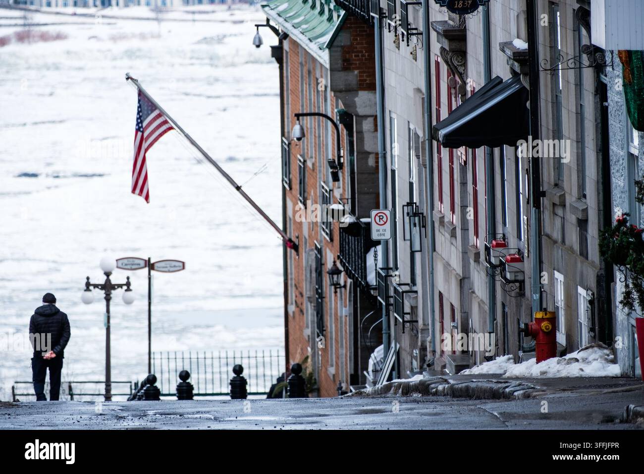 Un uomo passeggia sopra il ghiacciato fiume San Lorenzo a Québec City, Canada. Foto Stock