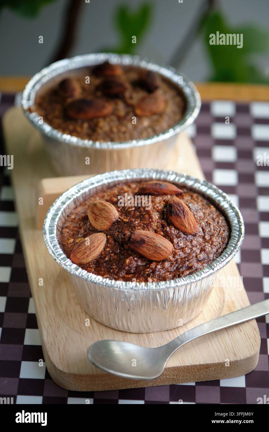 due cupcake al forno con banana guarniti con mandorle tostate sul tavolo di legno Foto Stock