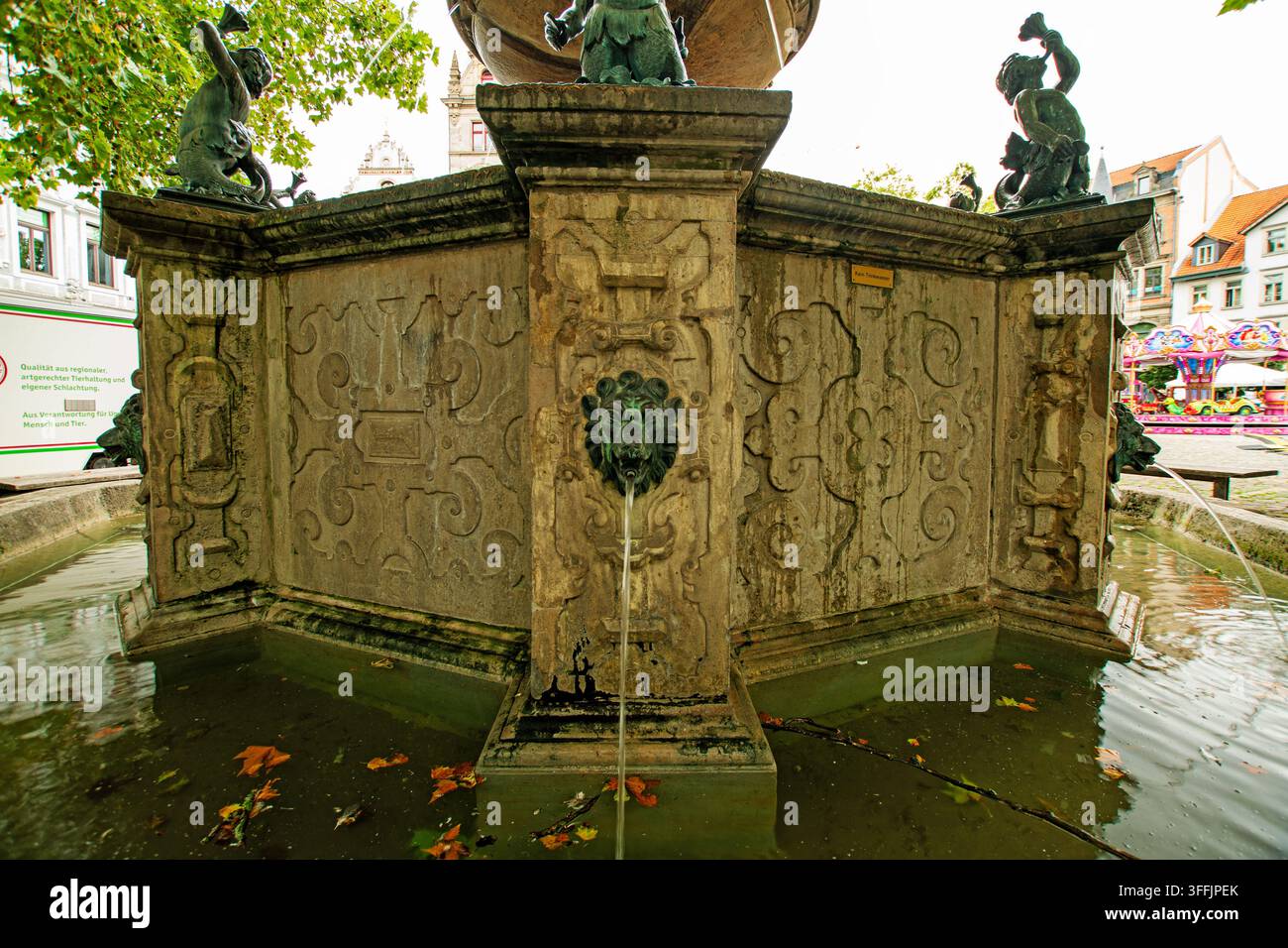 Fontana storica ornata con beccuccio d'acqua a testa di leone, figure scolpite e bassorilievi in pietra a Braunschweig, Germania. Foto Stock