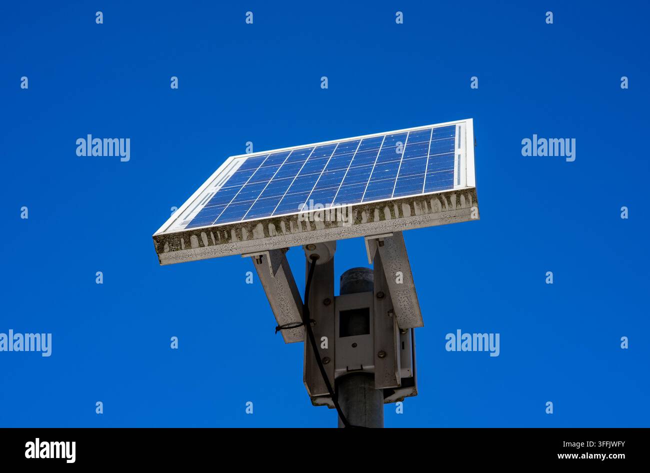 Installazione di lampioni stradali a pannelli solari sotto un cielo blu sereno Foto Stock