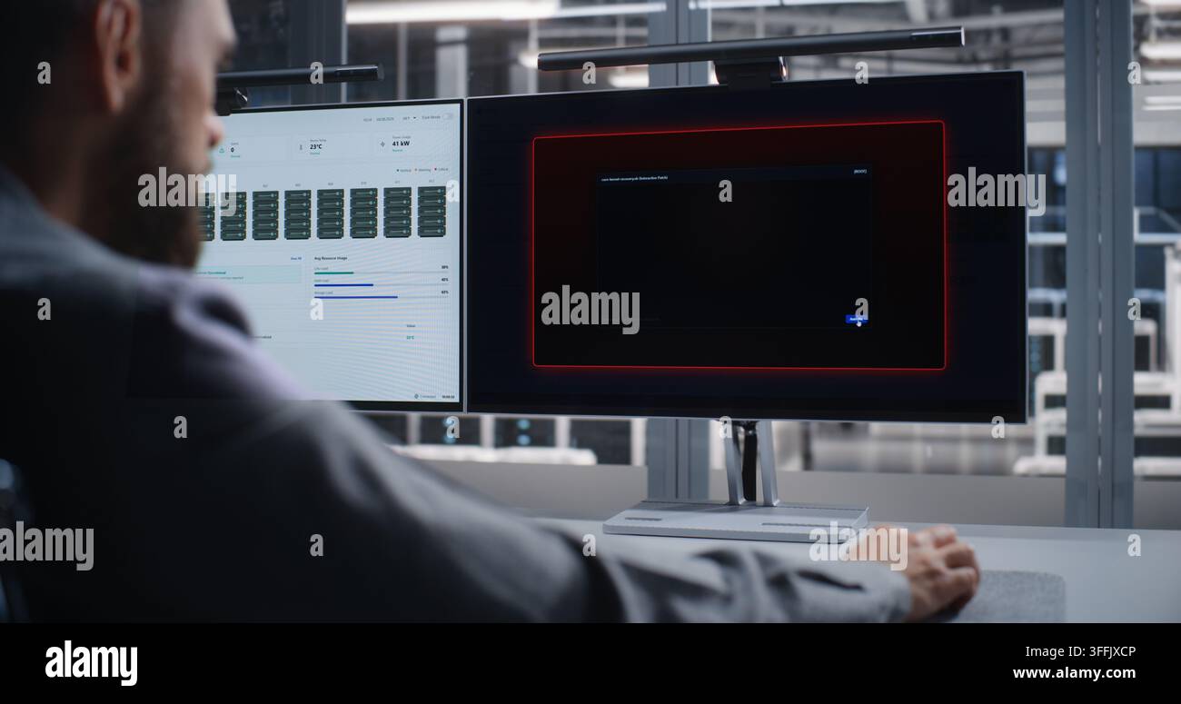 Professionista IT indaga un errore critico del sistema all'interno di un data center, utilizzando due monitor per analizzare le prestazioni dell'infrastruttura, risolvere i problemi dei server, mantenere l'affidabilità e prevenire tempi di inattività. Foto Stock