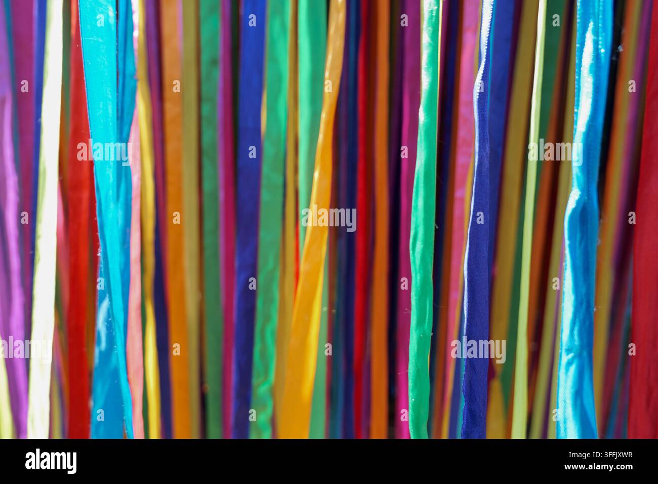 Nastri colorati appesi, all'interno, con nastri, da una prospettiva ravvicinata, con accenti blu, verdi e un'atmosfera luminosa e festosa, che mostra la vicinanza Foto Stock