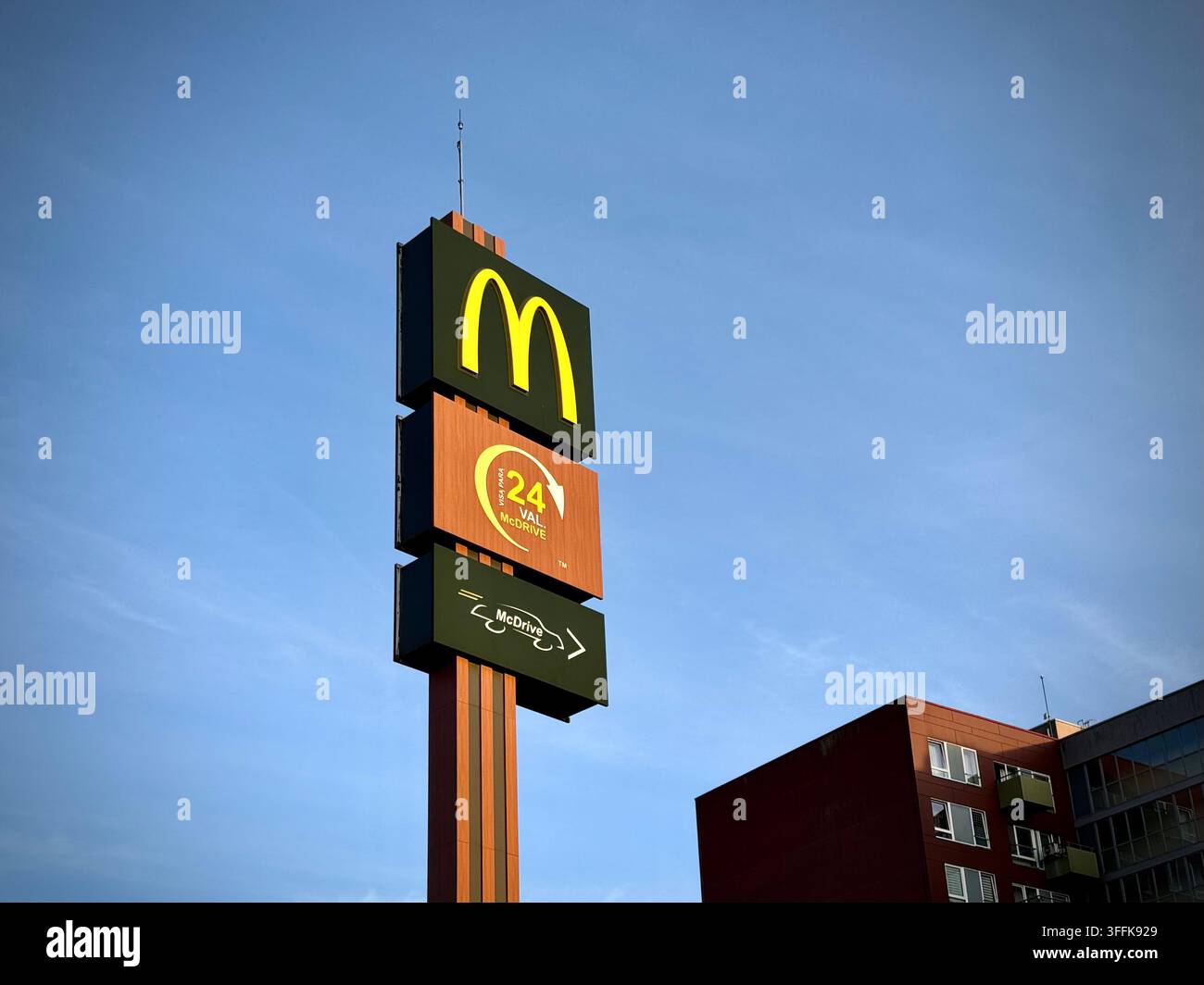 Foto ad angolazione bassa di un alto palo totem McDonald's 24/7 McDrive contro un cielo blu limpido a Vilnius, Lituania. - Immagine stock catturata con smartphone