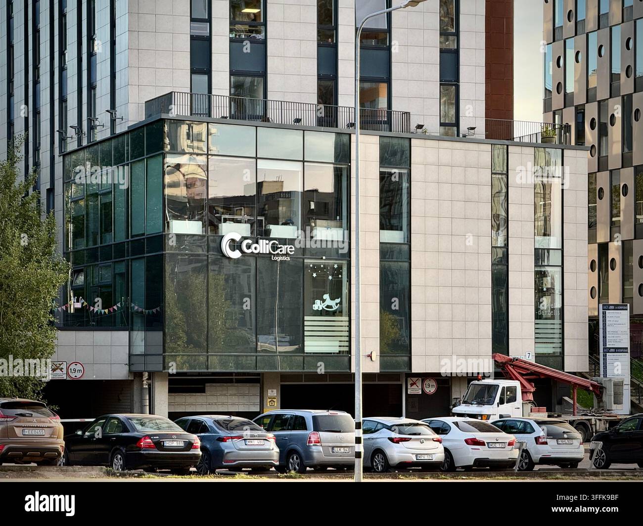Foto all’altezza degli occhi dell’edificio dell’ufficio di ColliCare Logistics al Mėnulio g. 7 a Vilnius, Lituania. Ideale per esigenze di foto d’archivio relative alla logistica 3PL - Immagine stock catturata con smartphone