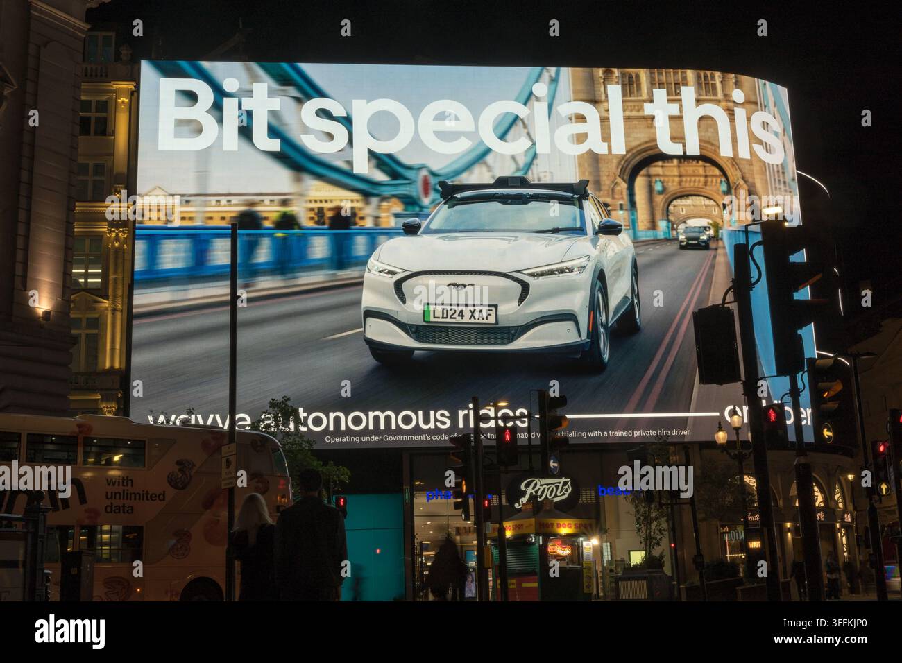 il gigantesco schermo Piccadilly Lights che mostra una campagna pubblicitaria Wayve, con un veicolo autonomo bianco che attraversa il Tower Bridge a Londra, UK Foto Stock