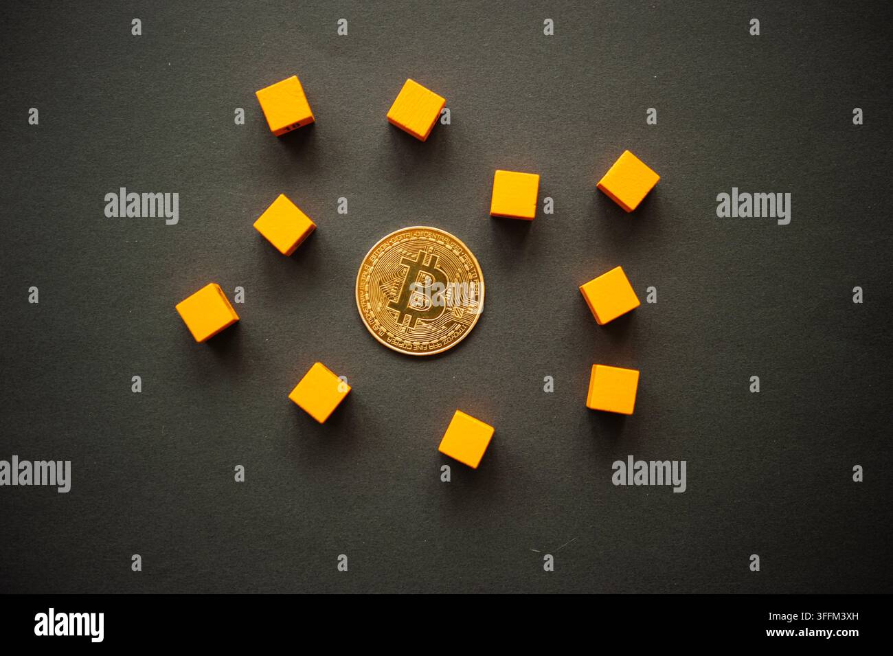 Moneta Bitcoin circondata da blocchi di legno arancioni su uno sfondo scuro, che illustra criptovalute, blockchain, finanza digitale e investimenti Foto Stock