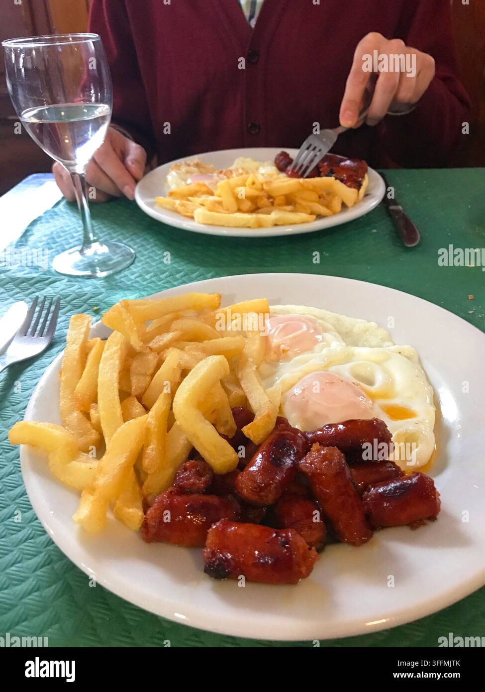 Uova fritte con chistorra e patatine fritte in un ristorante. Foto Stock