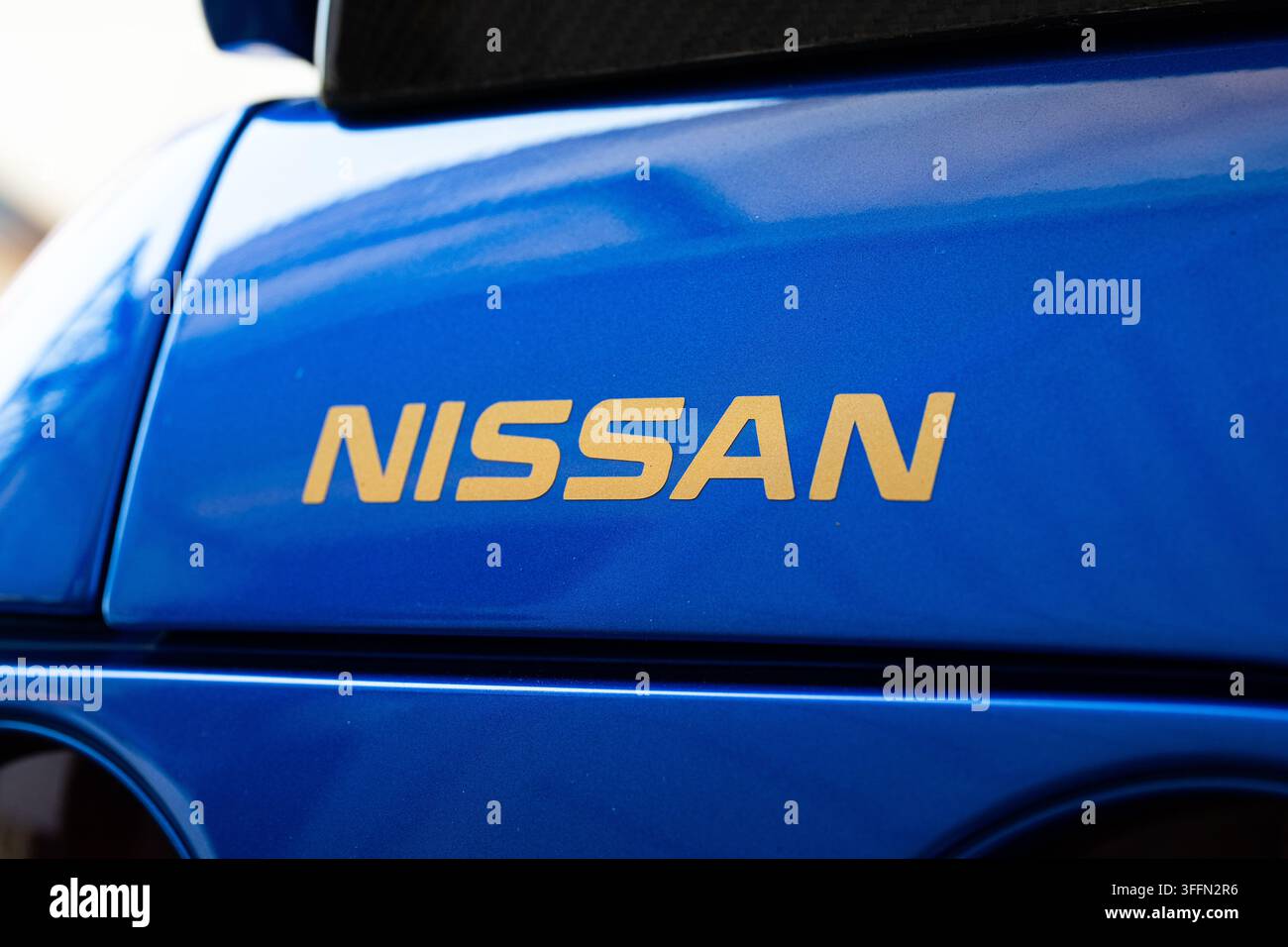 Kemptthal, Zurigo, Svizzera, 6 settembre 2026. Primo piano del testo della marca Nissan in oro sulla vernice metallizzata blu brillante di un'automobile sportiva giapponese Foto Stock