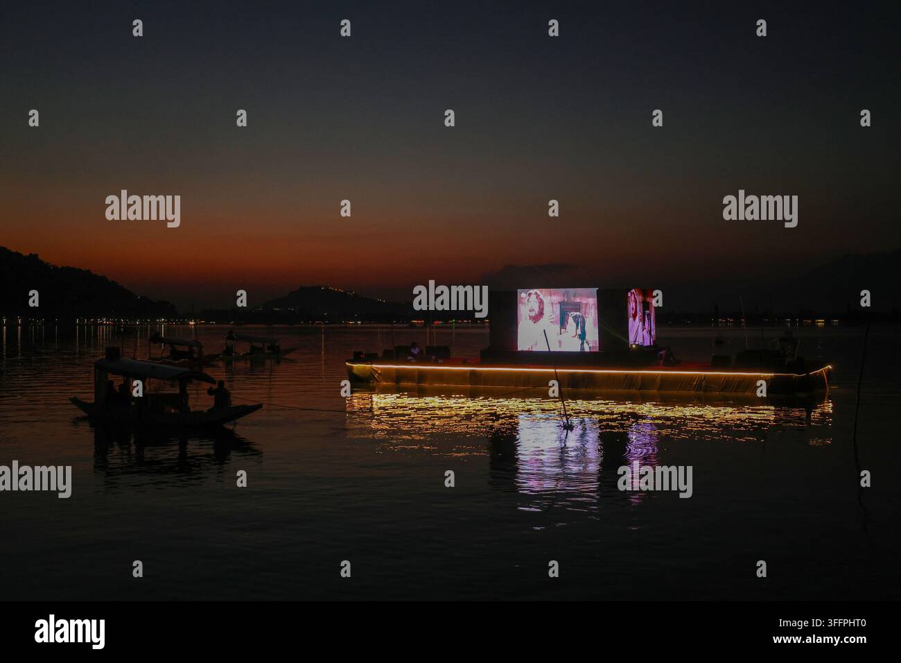 Srinagar, Jammu e Kashmir, India. 09 set., 2026. Un barcaiolo guarda una proiezione di film in un cinema galleggiante sul lago Dal durante il Festival internazionale del cinema del Jammu e Kashmir al Centro internazionale di conferenza Sher-i-Kashmir (SKICC) a Srinagar, Jammu e Kashmir, India, il 9 settembre 2026. Il festival di quattro giorni si svolge dal 7 al 10 settembre e presenta 135 film provenienti da 41 paesi. (Foto di Firdous Nazir/NurPhoto)0 Credit: NurPhoto SRL/Alamy Live News Foto Stock
