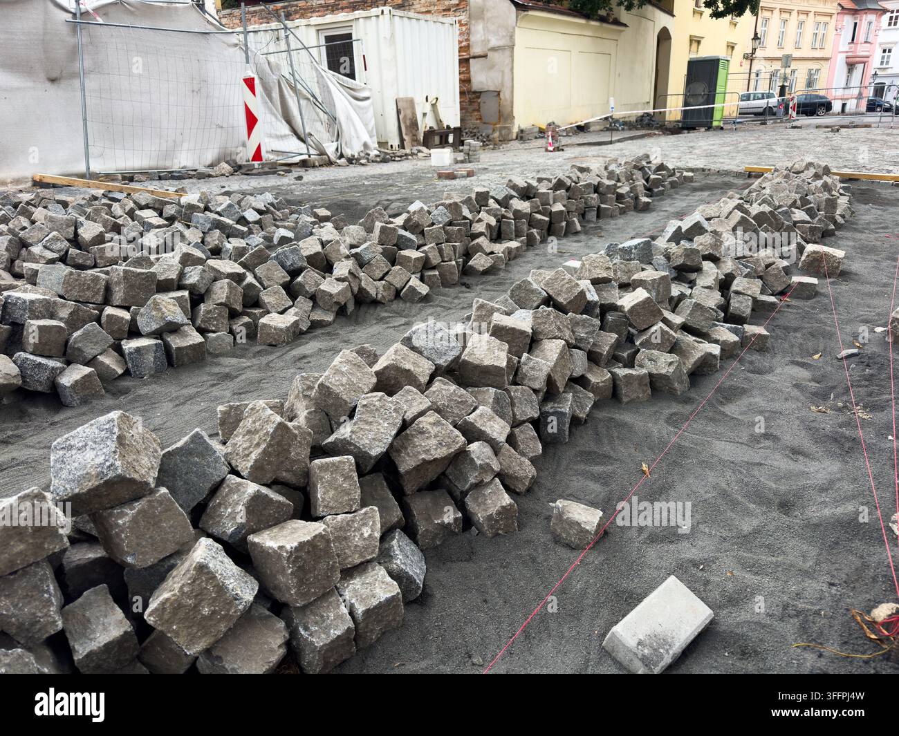Cumuli di pietre di granito per pavimentazione in un cantiere stradale, ristrutturazione urbana Foto Stock