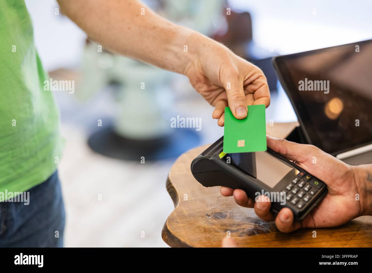 Cliente che effettua un pagamento contactless con carta di credito in un barbiere Foto Stock