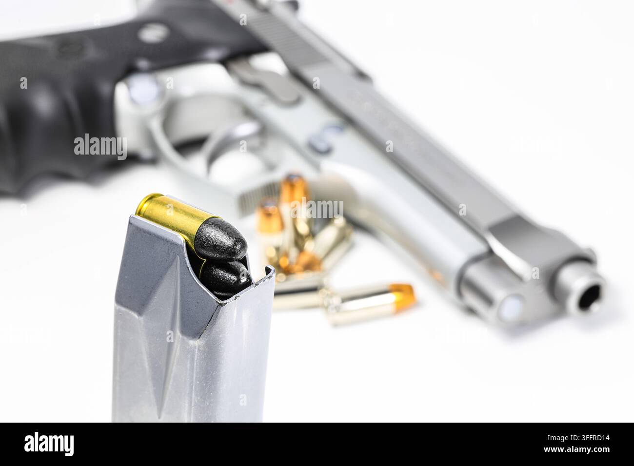 Proiettile 9 mm Parabellum con rivestimento in Teflon LRN ( naso tondo in piombo ) in caricatori e pistola postale da 9 mm sullo sfondo. Foto Stock